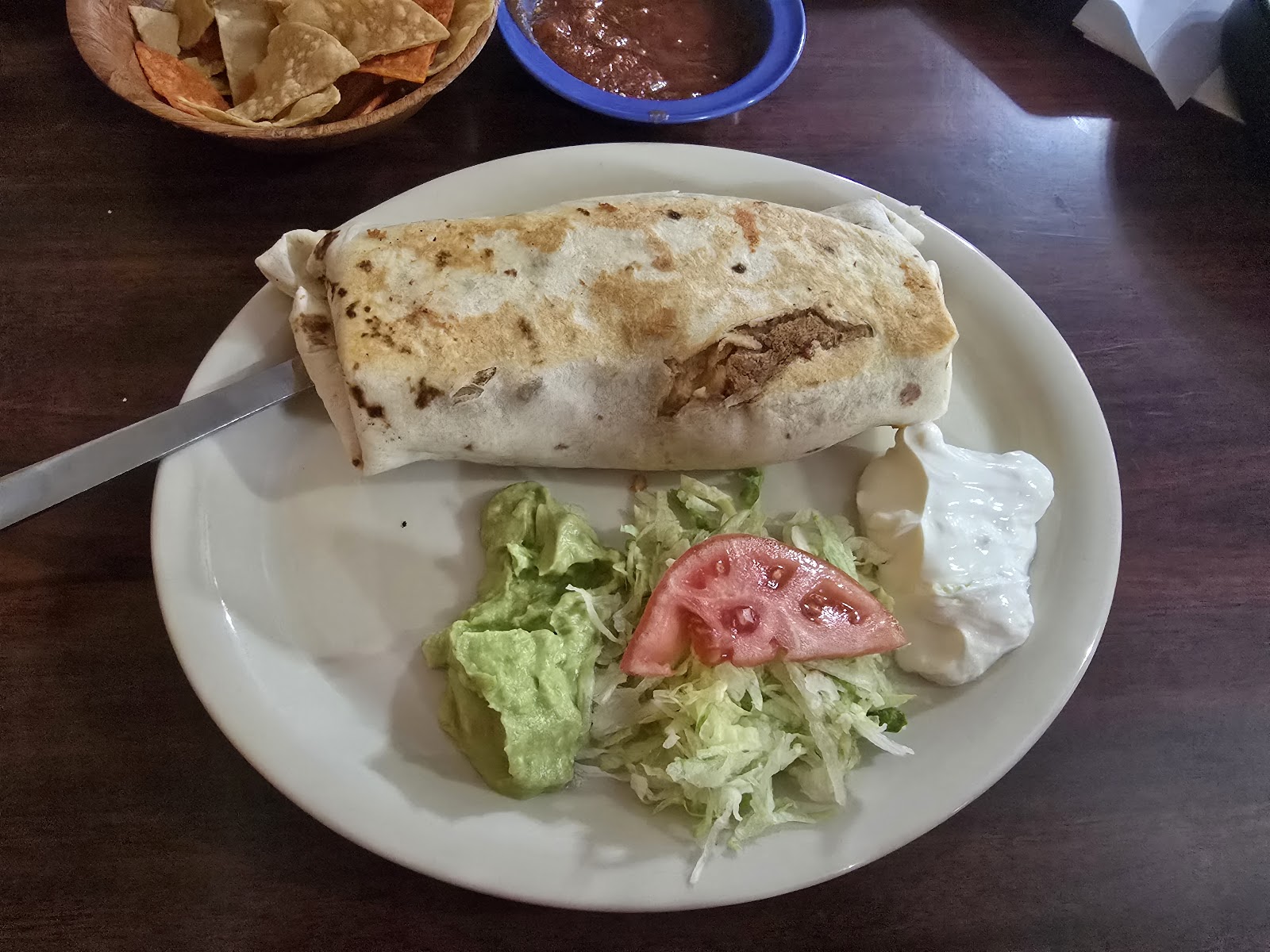 Grilled burrito plate with lettuce, tomato, and sour cream